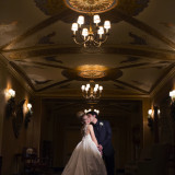 Groom Kissing the Bride in an elegant golden room at the Colony Club Detroit.