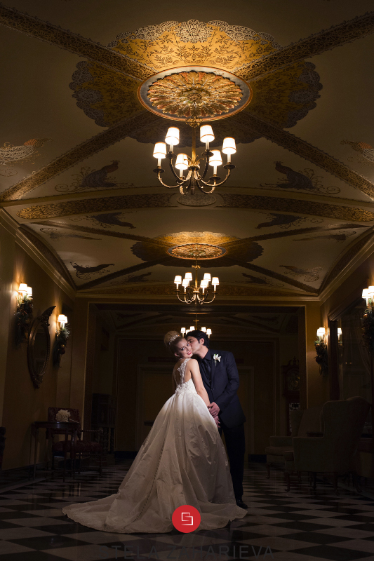 Groom Kissing the Bride in an elegant golden room at the Colony Club Detroit.